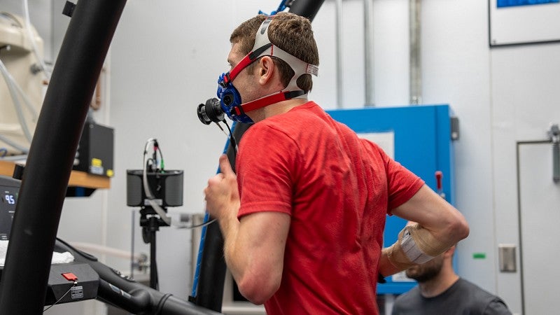 Man with connected to monitoring equipment running on a treadmill