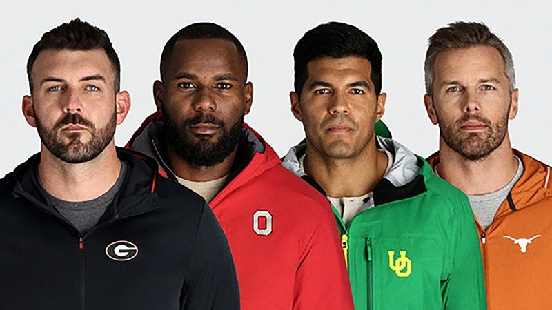 Four men wearing different rain jackets with college logos