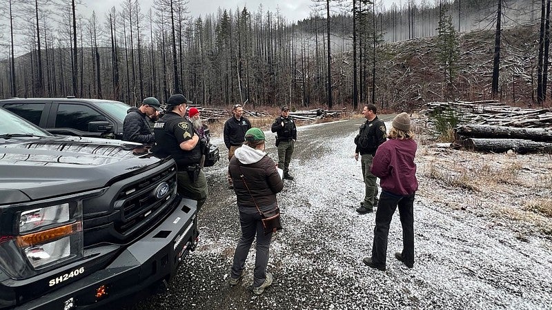 Students talking with law enforcement officers on a remote logging road