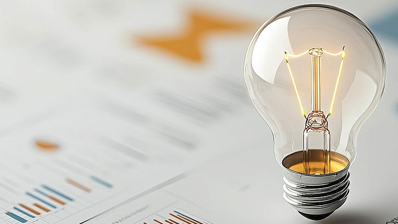 A lightbulb sitting atop graphs and charts to represent entrepreneurship