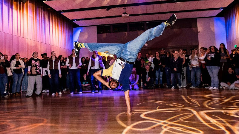A breakdancer doing moves in front of a crowd