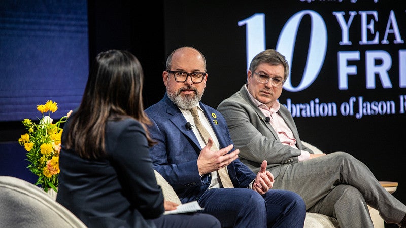 Three people on a stage talking