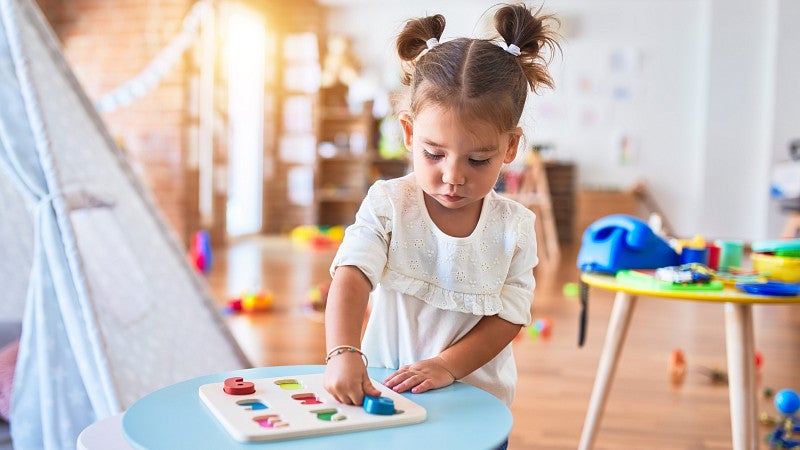 a child plays with a box of colorful items