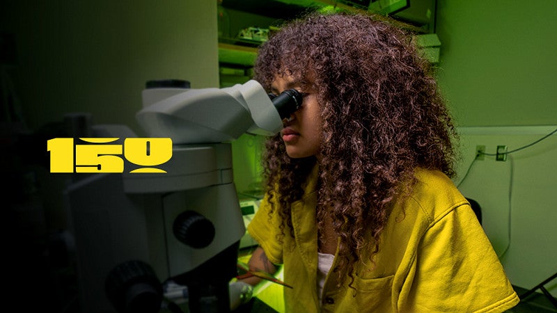 A woman looking through a microscope