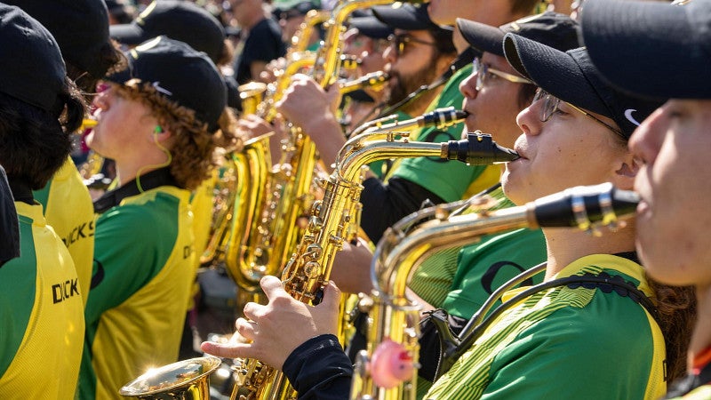 Members of a marching band play instruments