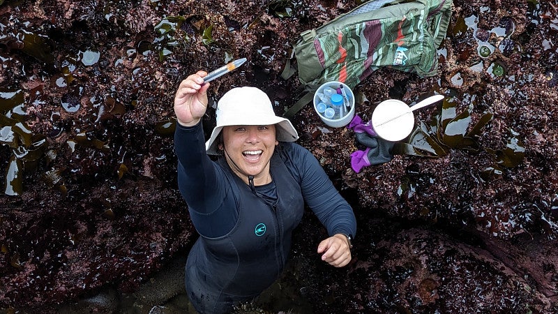A scientist holds up a sample in excitement