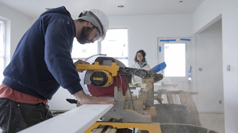 Student sawing baseboard