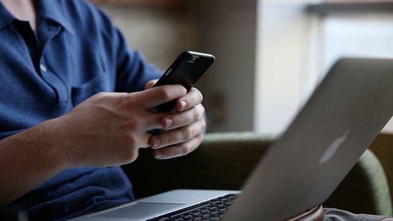 Image of person using laptop and cellphone