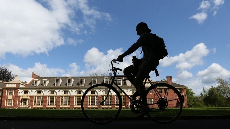 A bicyclist passes in front of Gerlinger Hall.