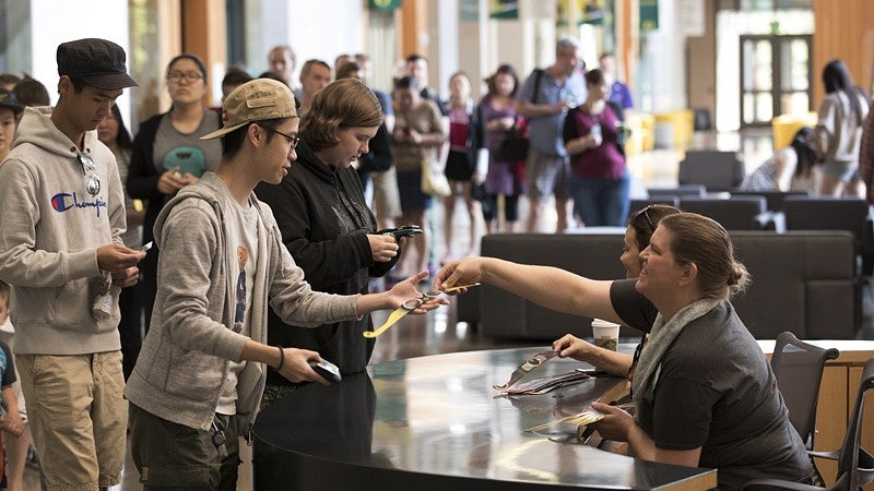 Students pick up eclipse glasses at the EMU prior to the big event