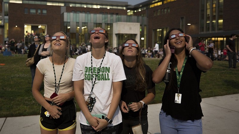 Incoming members of the UO softball team take in the eclipse