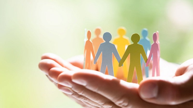 Hands holding paper-doll people