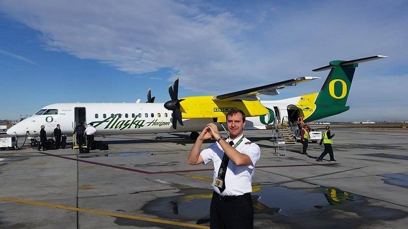 Horizon Air pilot Ted Parish, '06, and his favorite plane on the tarmac at Pasco, Washington
