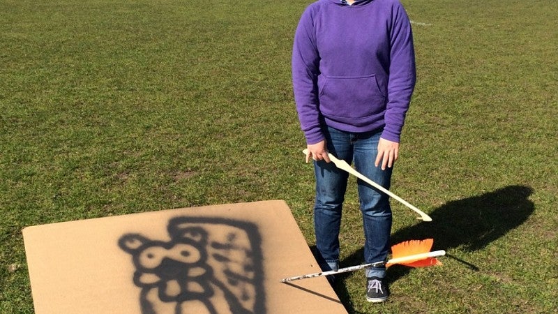 Josie Greer stands by the target she hit with her atlatl