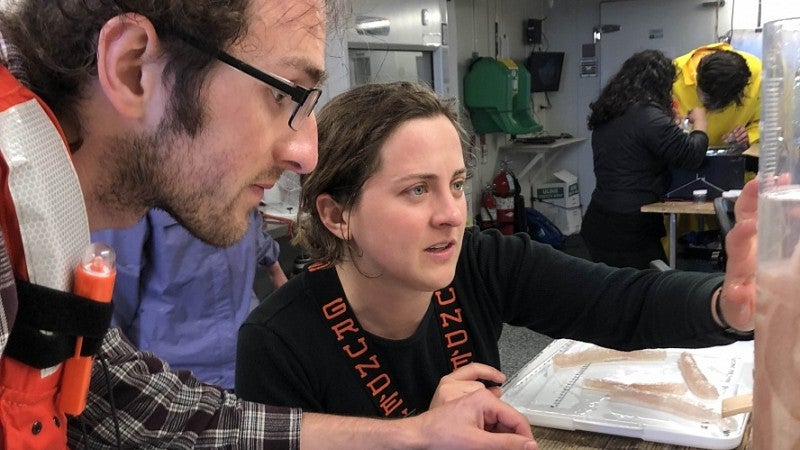 Matt Gimpelevich and Sam Zeman examine pyrosomes captured in the Pacific Ocean