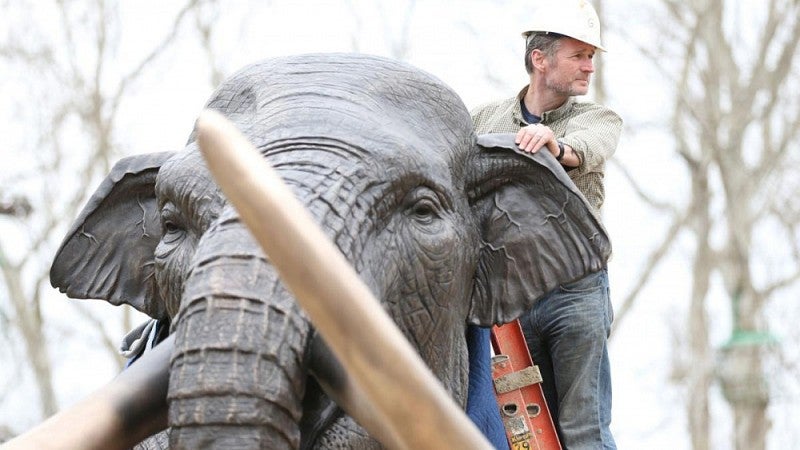 Artist on mammoth sculpture