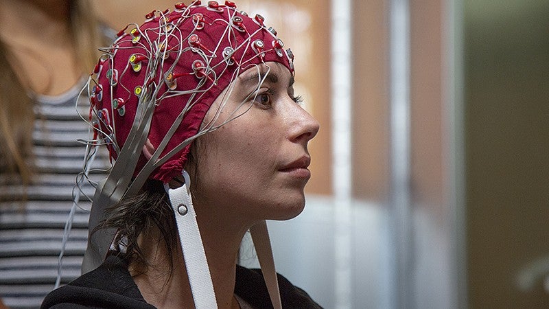 Image shows a subject wearing cap covered in electrodes