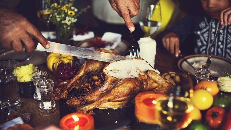 Hands carving a Thanksgiving turkey