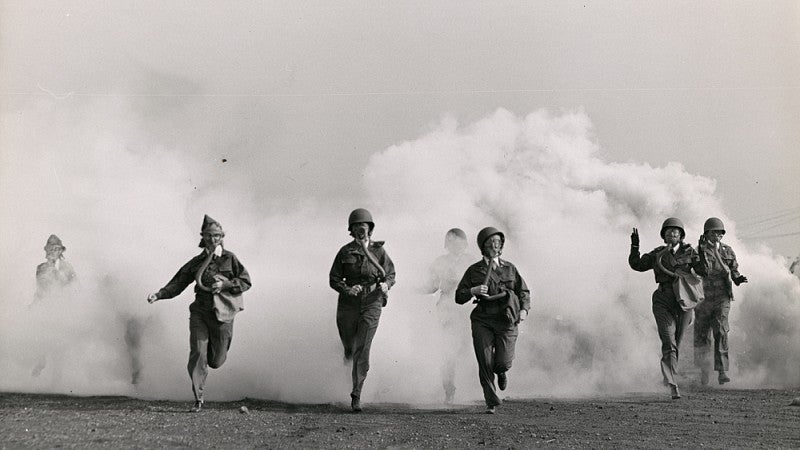 Women in gas masks in cloud of smoke