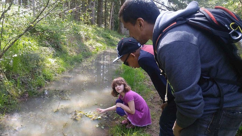 Students from Creston Elementary School look for newts in a creek