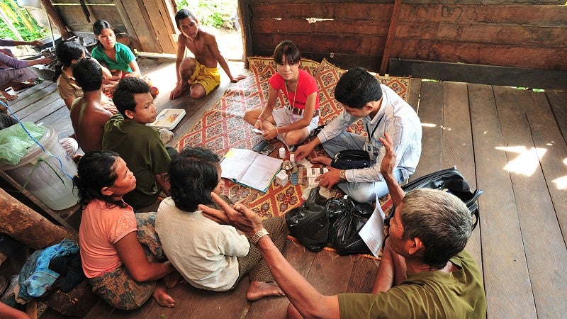 A doctor making a home visit in a rural area of Laos.