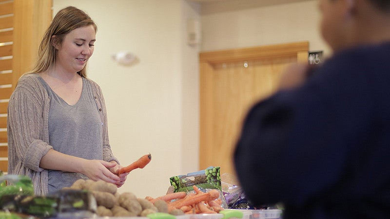 Kiara Kashuba interning with Cornerstone Community Housing in partnership with Food for Lane County at Willamette Gardens 