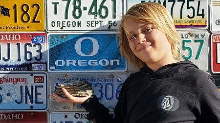 Jeremiah Longbrake showing off a portion of a fossil mammoth tooth