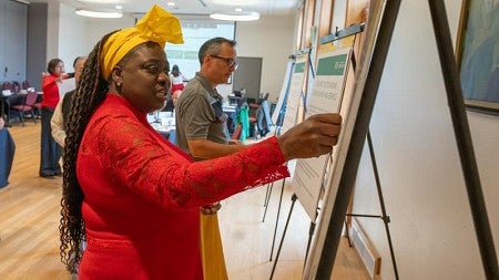 Woman making comment on poster at a strategic plan meeting