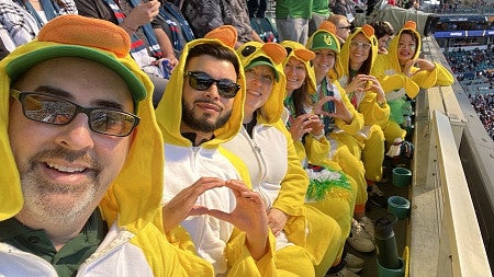 UO employees dressed in Duck outfits at a football game