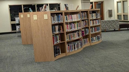 A shelf of books in an open study room