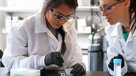 Knight Campus Undergraduate Scholar Michelle Hernandez with her mentor, Kelly Hyland, working in a lab 