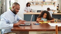 Parent working at dinner table