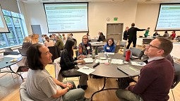 UO staff and faculty working at tables during mentorship session