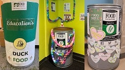 Three decorated food drive barrels