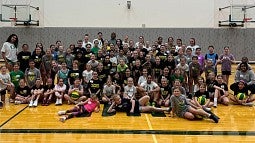 youth campers gathered on a basketball court at a UO basketball summer camp