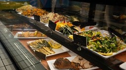 assortment of food on serving trays in deli case