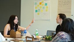 three attendees talk at the learning cafe