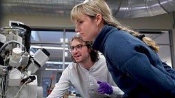 A male and female student looking at a screen in a research lab