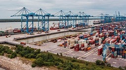 A quiet cargo port with cranes and containers