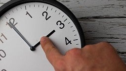 Photo of a person moving clock hands back