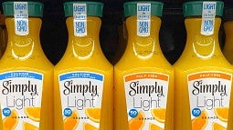 Row of Simply brand orange juice on store shelf