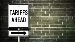 Sign reading 'Tariffs Ahead' in front of a brick wall