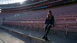 Julia Goldstein sitting in the empty stands at Rose Bowl Stadium