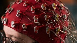 Woman wearing a cap with many electrodes attached