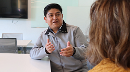 A man at a table speaks with a woman