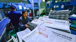 Workers printing a Chinese newspaper controlled by the Communist Party