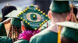 Students in mortarboards, including one with small decorative ducks on the top