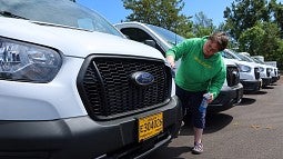 Office specialist Lysha McDowell applies the shine to one of the UO Motor Pool’s 2025 Ford 12-passenger Transit vans