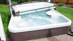 A hot tub with the lid half open