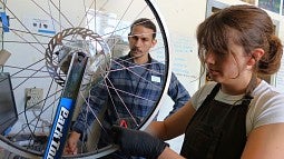 Recent graduate Scout Gesuale (right) learned something new about bike repair every day working as a mechanic with Logan Devack, bike program manager (photo: Matt Cooper)